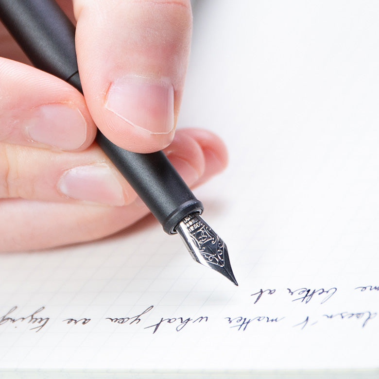 open note book with black rollerball pen on it#45031769571631