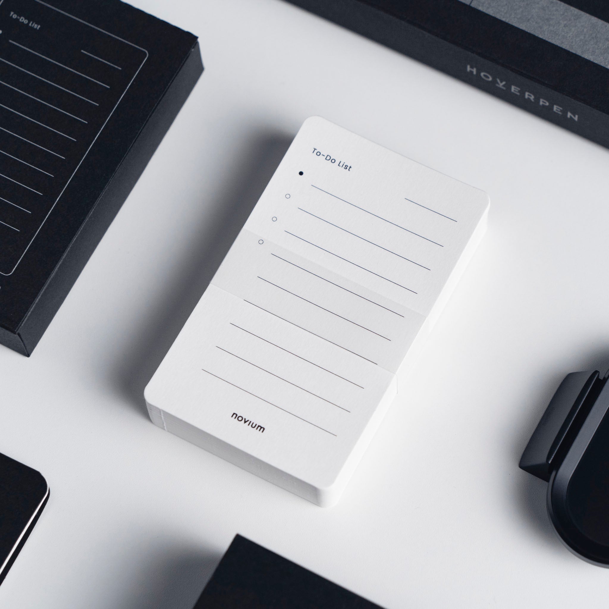 The cards are designed with nine lines for tasks neatly arranged on a white surface. A novium black office set surrounds it.